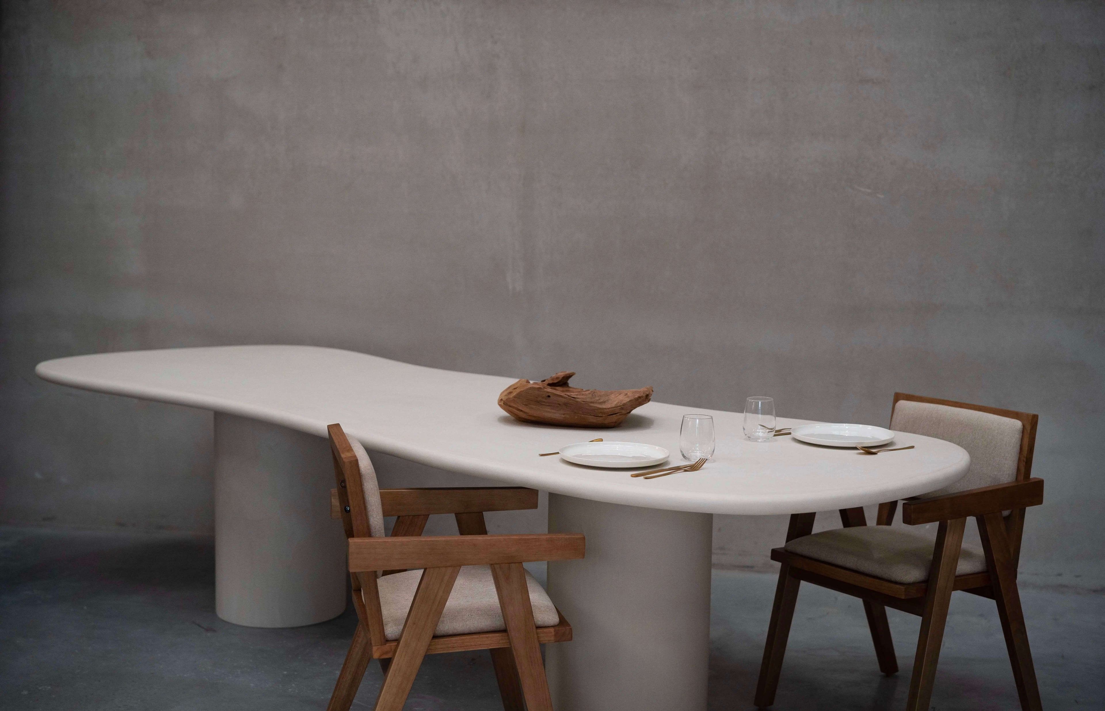 Table de forme organique en béton ciré Mortex® avec deux chaise en bois