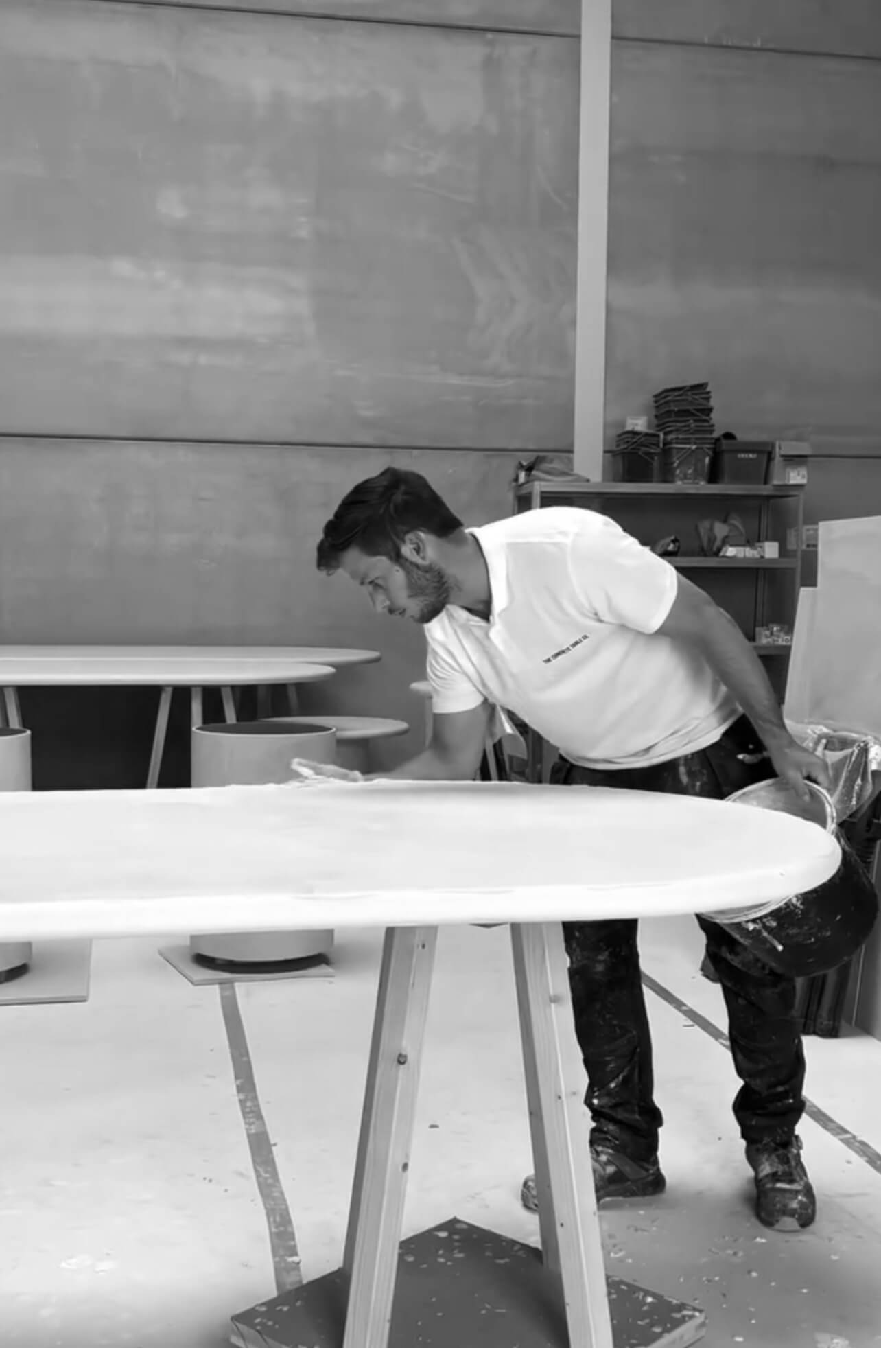 Artisan appliquant du Mortex à la main sur une table en béton ciré dans l’atelier de fabrication the concrete table co