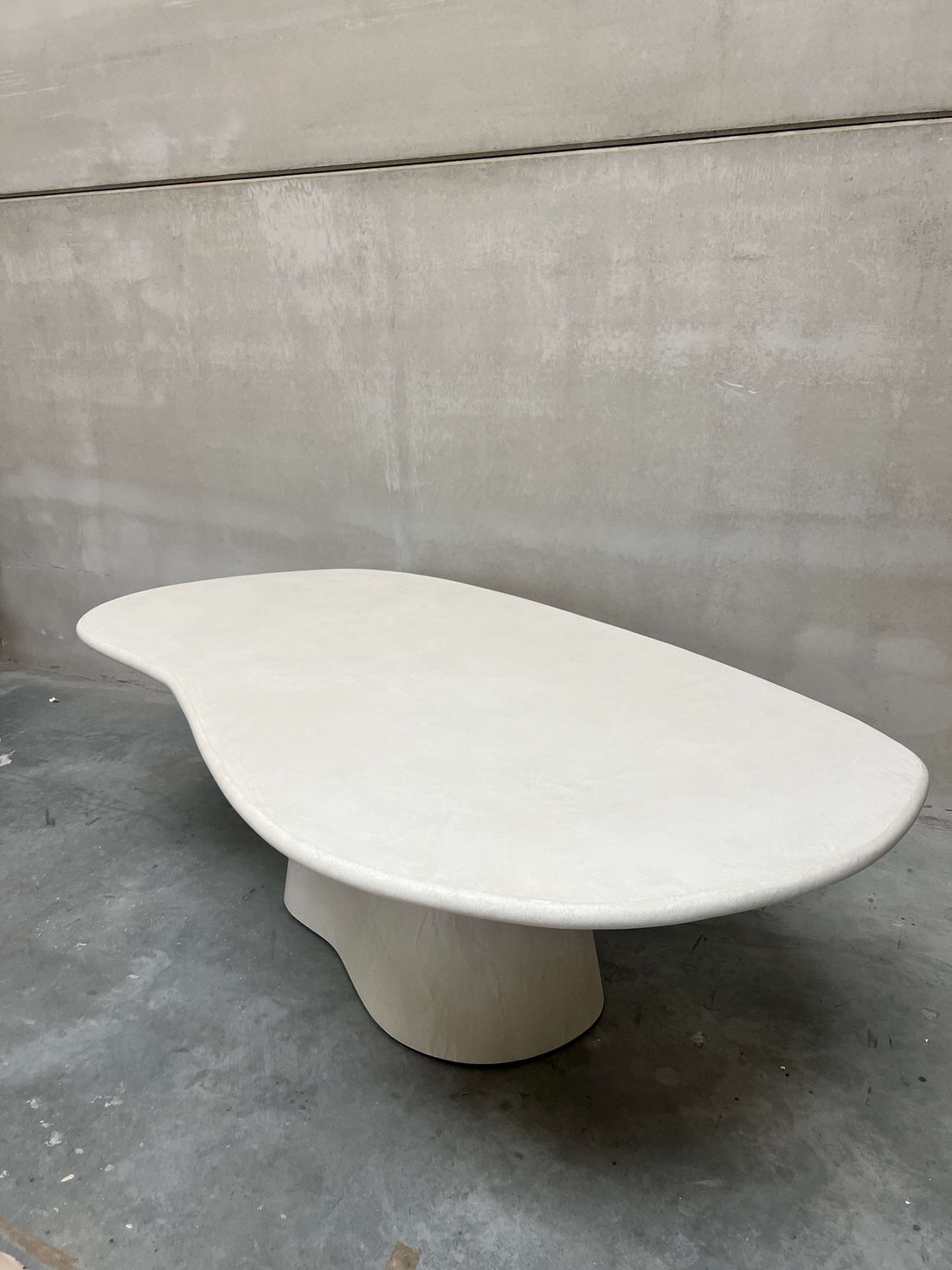 Vue de dessus de la table à manger Eline en Mortex® sur un sol en béton dans l&