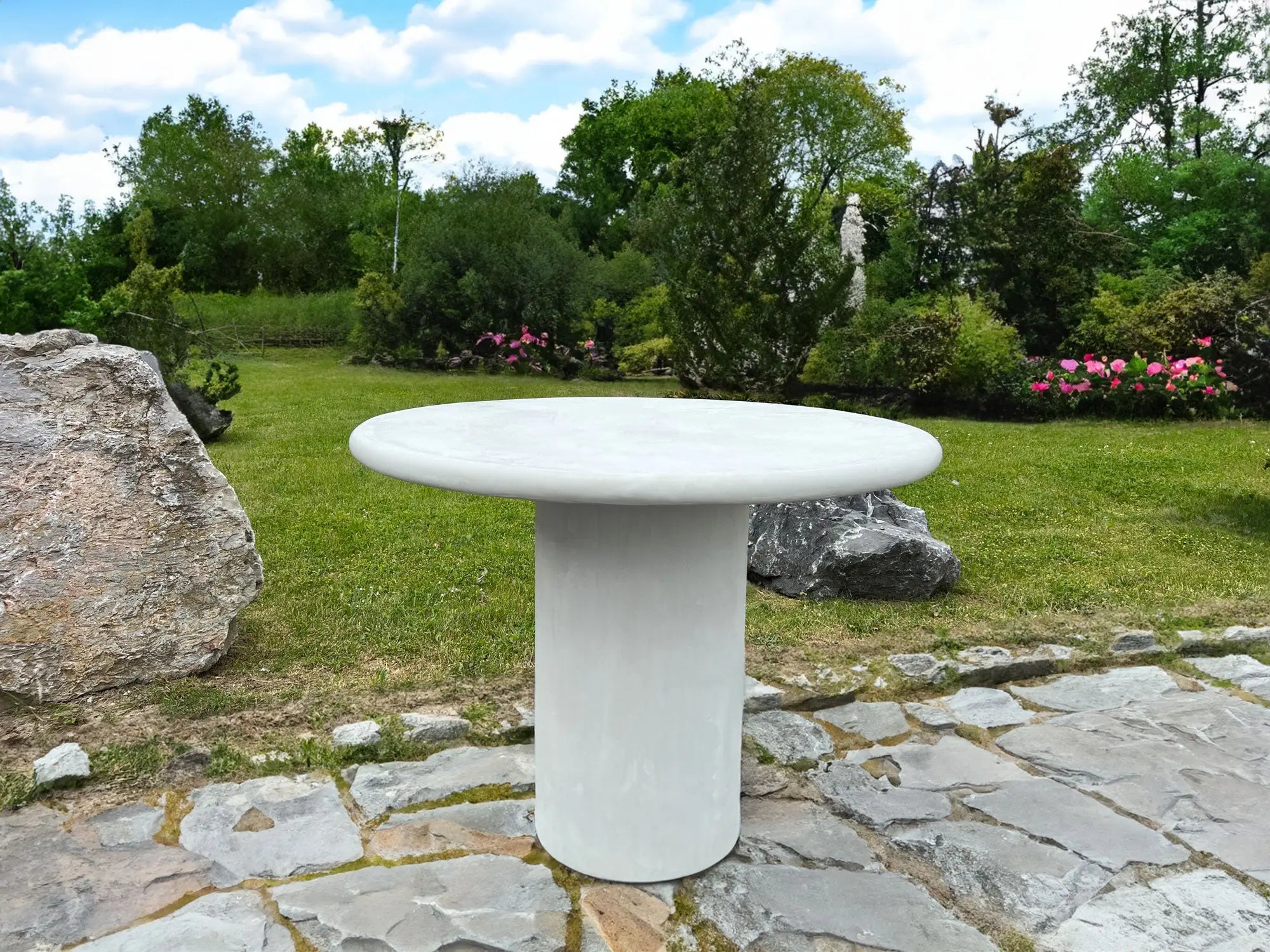 Nia - Table ronde MORTEX® installée dans un jardin, vue en situation
