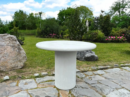 Nia - Table ronde MORTEX® installée dans un jardin, vue en situation