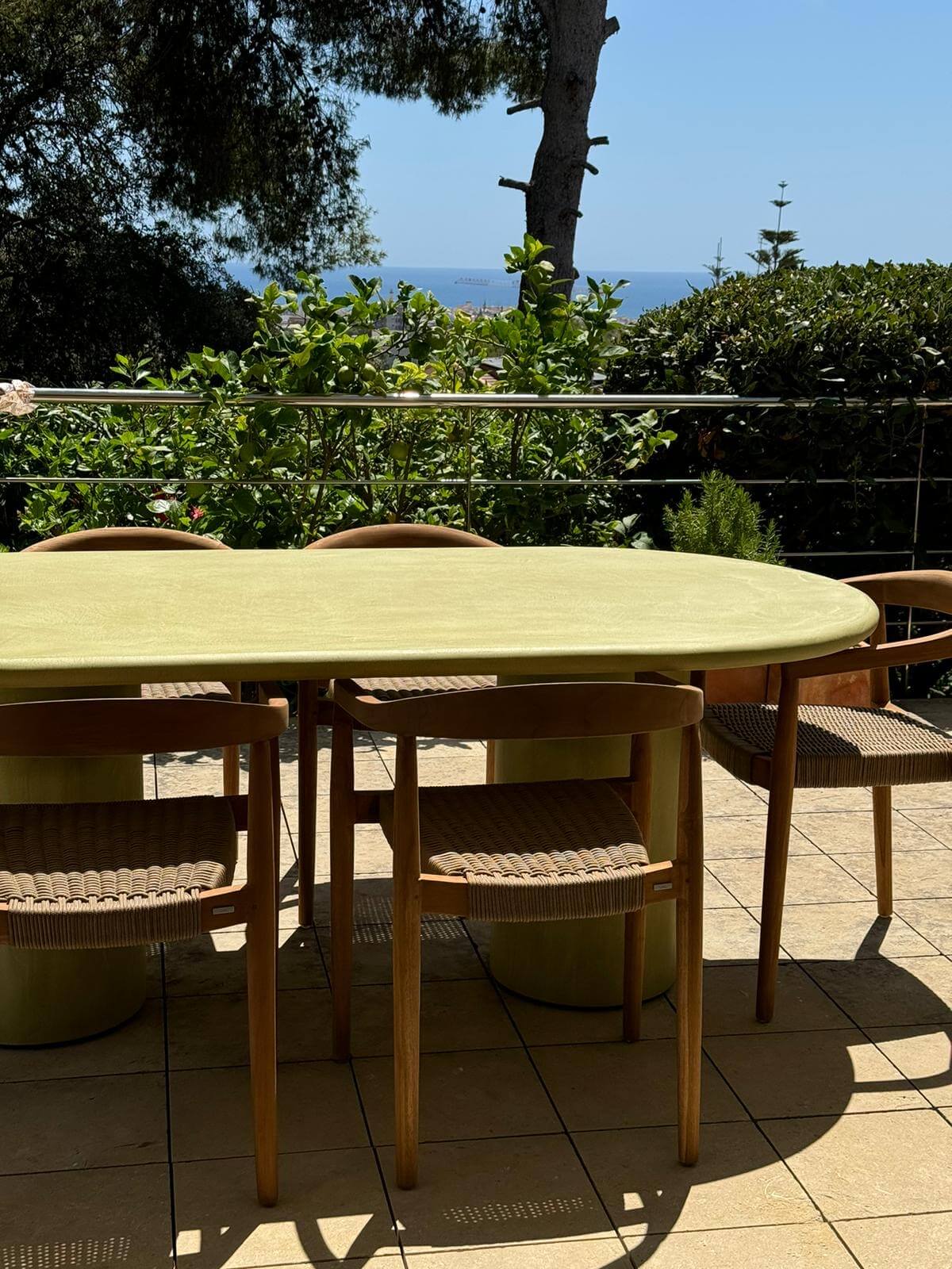 Table à manger extérieur vert olive de forme ovale en mortex® vue sur mer